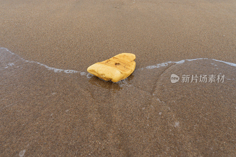 黄色塑料泡沫污染了海滩，造成了环境污染和污染。人类造成的环境问题导致了海洋的严重问题。