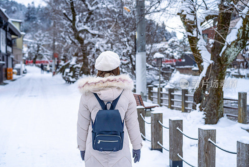 美丽的女游客享受他们的日本之旅在雪的冬天