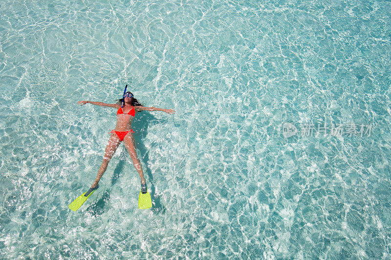 女人漂浮在清澈的水面上