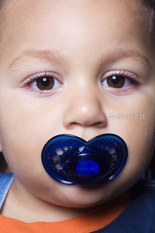 幼儿男孩(18-21个月)嘴里含着奶嘴，肖像