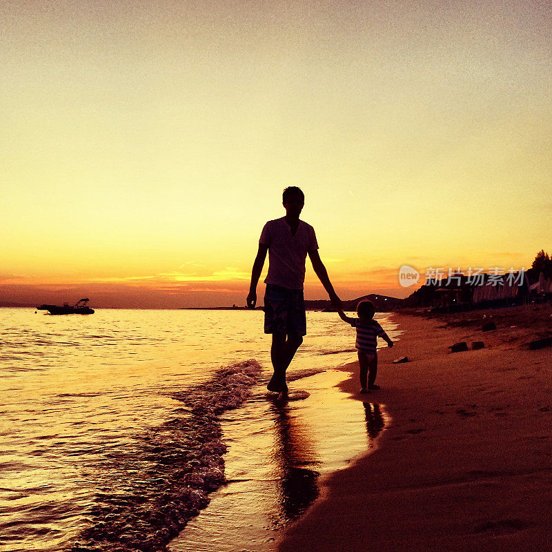 父亲和儿子在海滩上散步