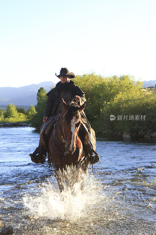 骑马穿过小溪的牛仔