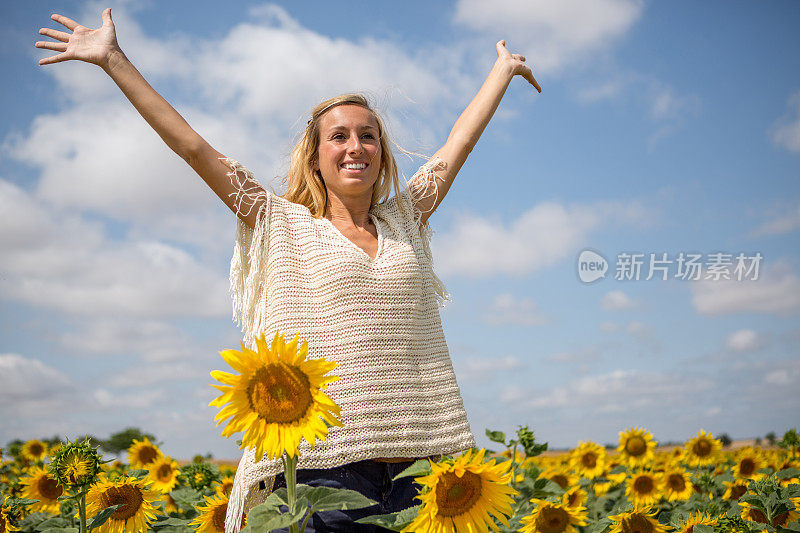 快乐的女人在向日葵地里享受大自然