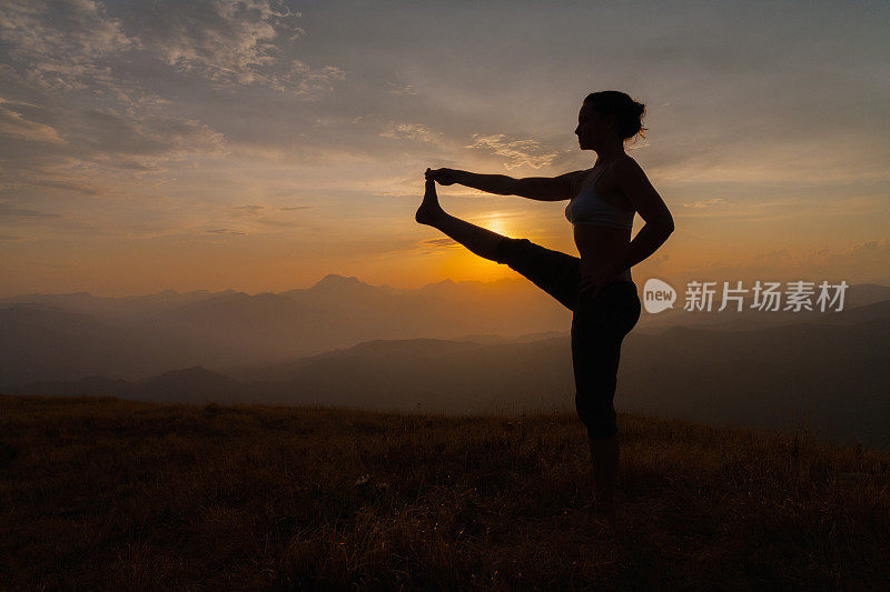 在日落时练习瑜伽的女人