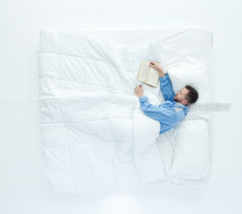上图是躺在床上看书的人
