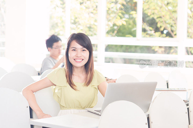 亚洲女孩在教室里用笔记本学习