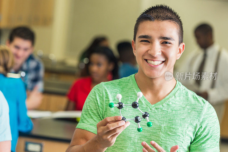 一个高中生在科学课上拿着分子模型