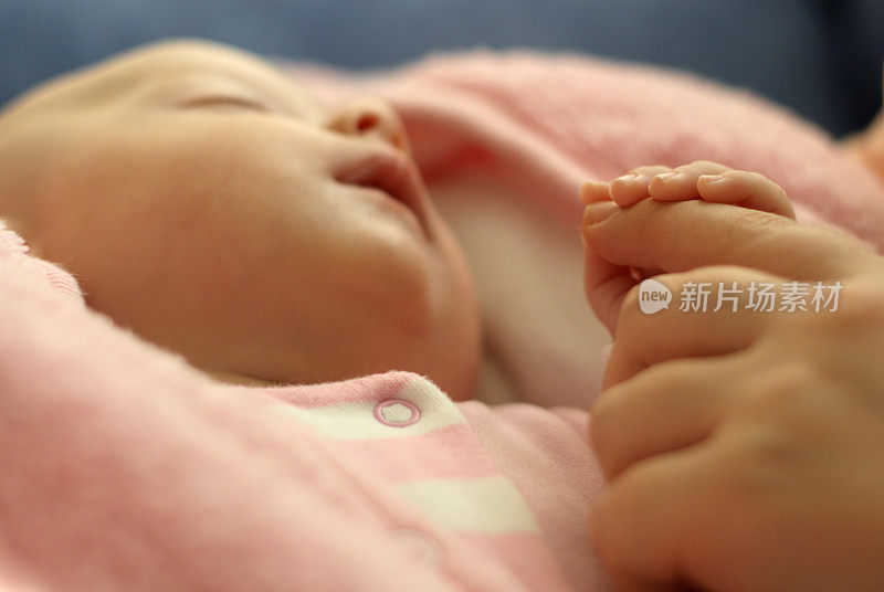 熟睡的新生婴儿牵着妈妈的手
