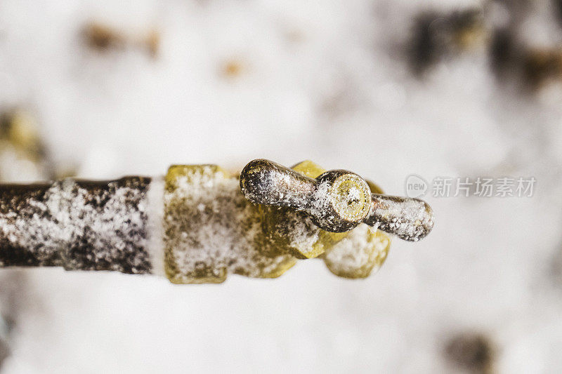 冰冻的户外水龙头上覆盖着雪花