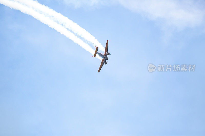 飞机拖着缕缕烟雾在空中翱翔