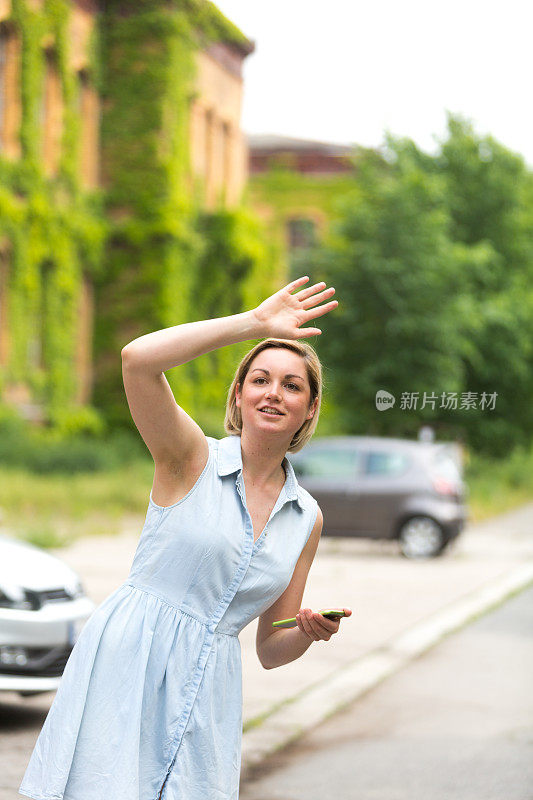 年轻女子拿着手机找出租车