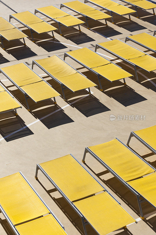 阳光甲板上空荡荡的黄色日光浴床