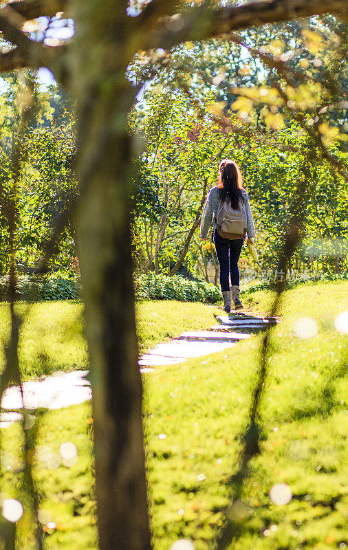 秋天，一个少女在公园的小路上散步