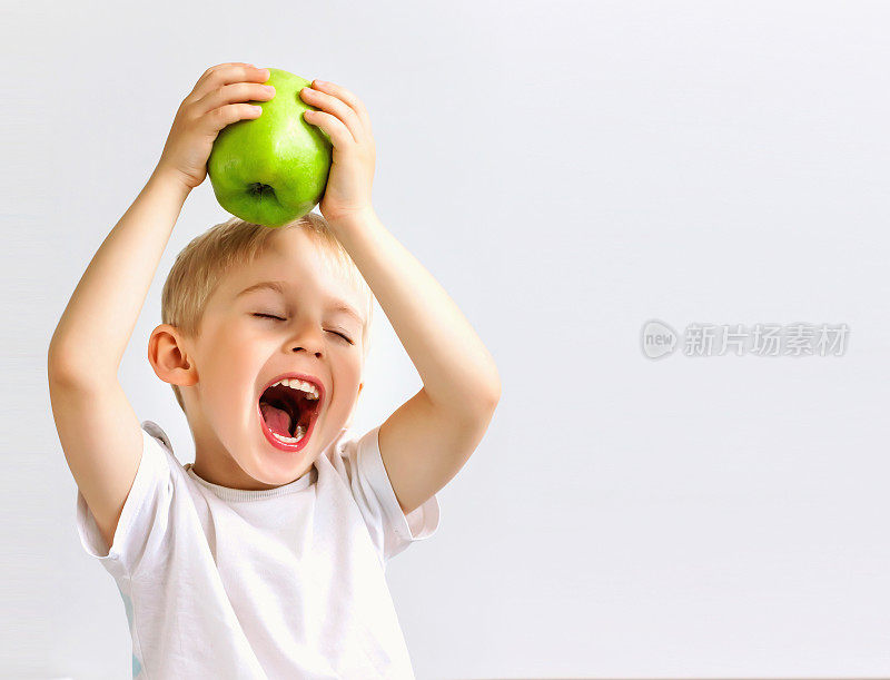 小男孩拿着一个绿色的大苹果，