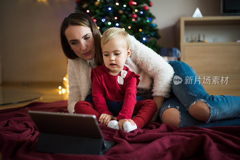 母亲和女儿在圣诞节使用电子平板电脑