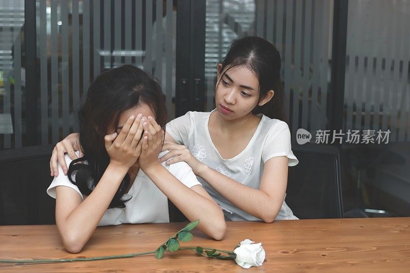 复古色调的沮丧压力亚洲女人安慰一个悲伤沮丧的女性朋友的形象。分手或最佳关系概念。
