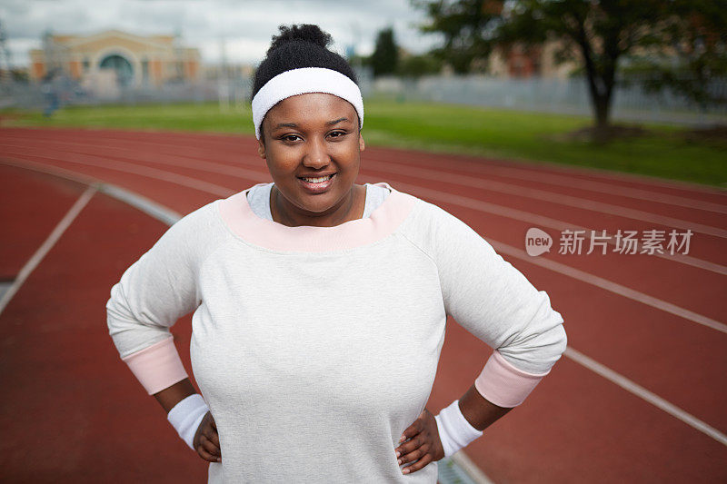 自信超重的非洲妇女在体育场锻炼前对着镜头微笑的肖像