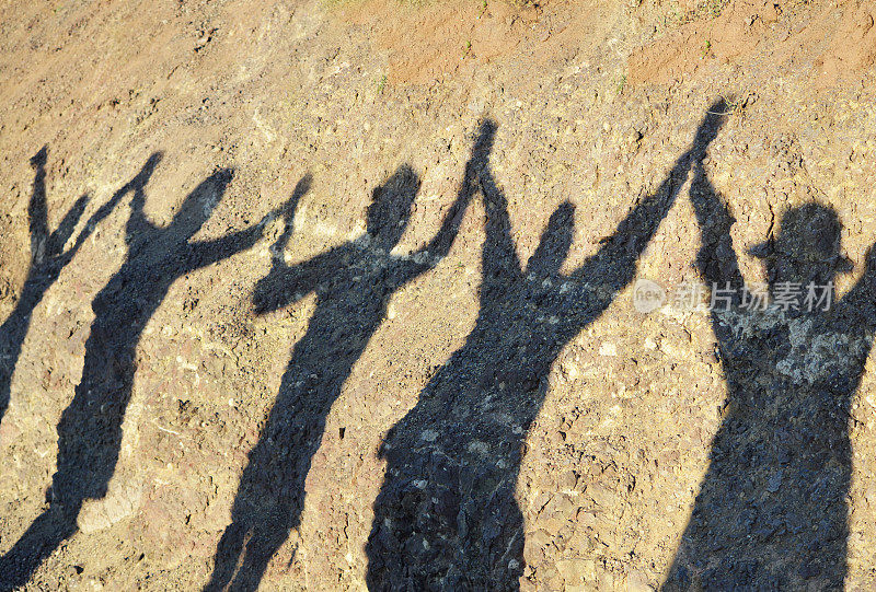 团结、成功和友谊的理念，阴影下的一群妇女在登山后手牵手