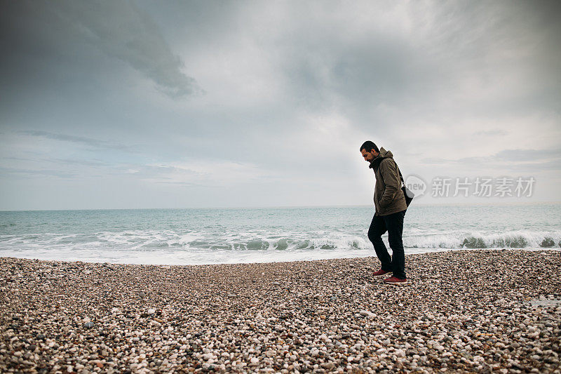 下雨天在海滩上散步的人