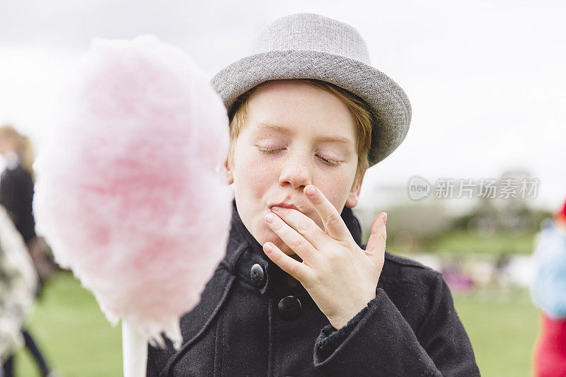 男孩在吃粉红色的棉花糖