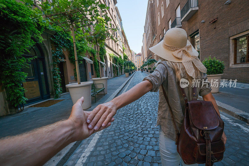 跟我去罗马;女友牵着男友的手走在城市的大街上，分享浪漫城市中的情侣时刻