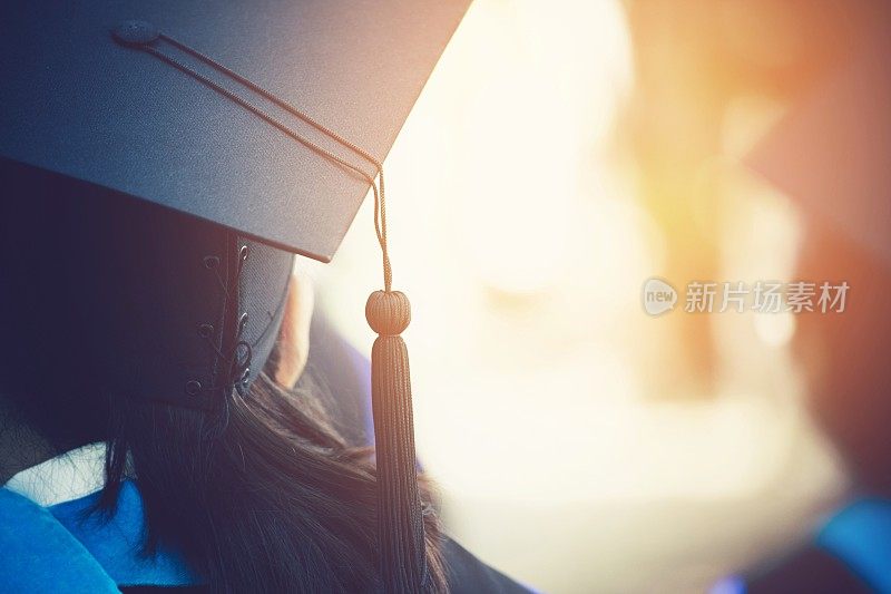 毕业典礼上，学生们手拿帽子成功毕业的大学，观念教育祝贺。毕业典礼，祝贺大学毕业生。