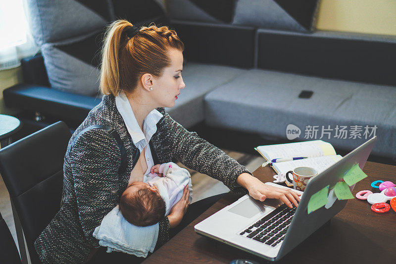 母亲工作和哺乳她的孩子在办公室