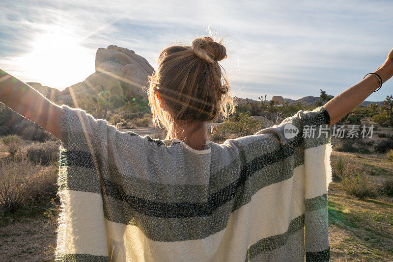 夕阳西下，幸福的年轻女子张开双臂站在大自然中;拥抱生活理念的幸福人士