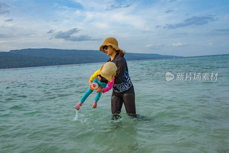 母亲和女儿在海边玩耍