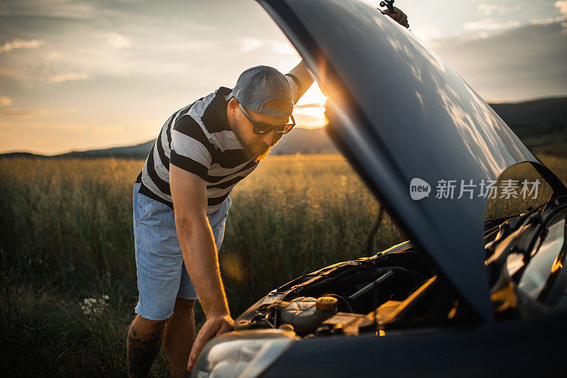 夕阳下，一个人在乡村公路上修车