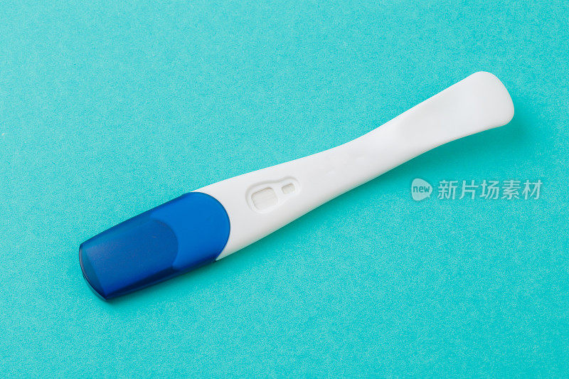 蓝色背景上的白色塑料妊娠试验。