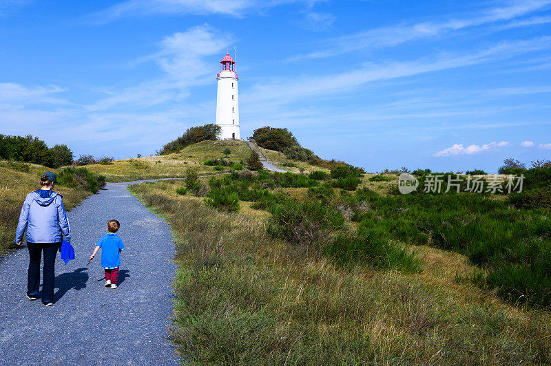 母亲和儿子走向多恩布希灯塔位于德国希登湖岛北部海岸附近。