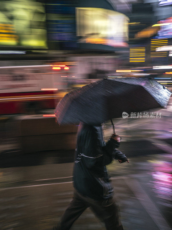 在曼哈顿带着雨伞行走的男人