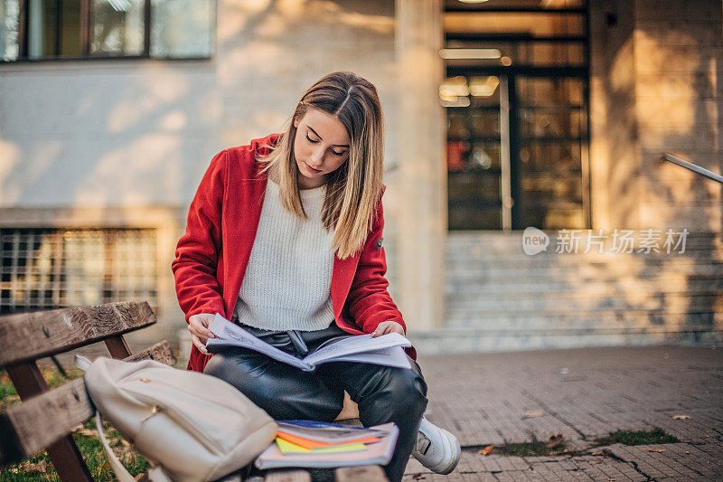 女学生坐在长凳上学习