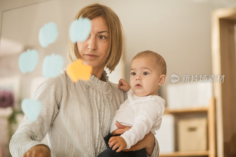 婴儿和她的妈妈透过窗户看