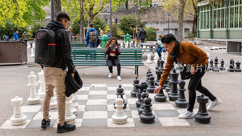 人们在堡垒公园玩传统的超大号街头象棋。