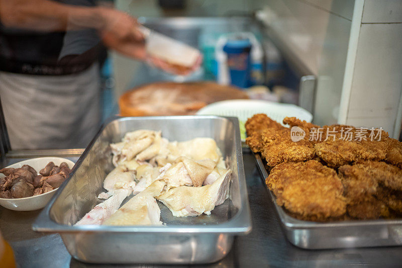 泰国鸡饭小贩在他的摊位上准备食物