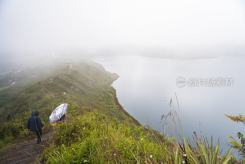 游客们沿着厄瓜多尔雾蒙蒙的Cuicocha湖徒步旅行