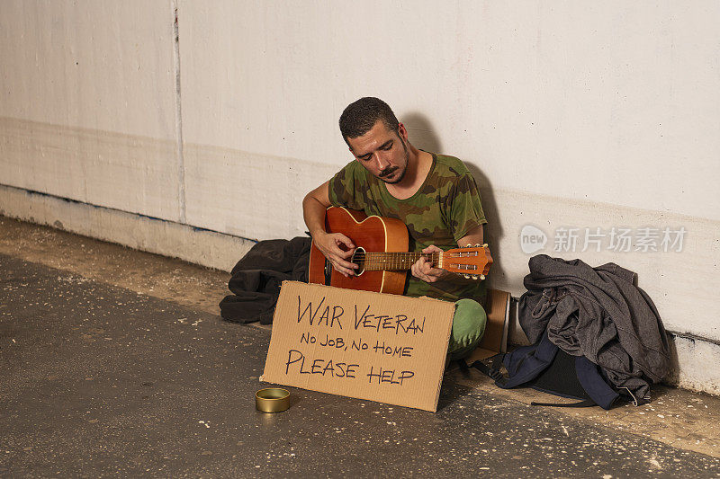 一个年轻人在地下弹吉他，等待救援