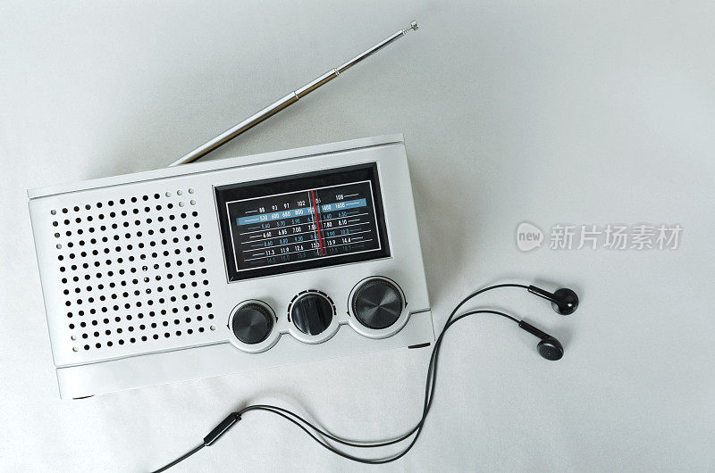顶视图的复古收音机和耳机上的灰色表面。音乐的概念和不同的设备听音乐