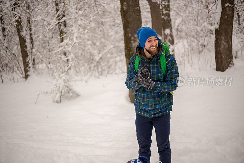 年轻英俊的男子在滑雪运动服山和看别处