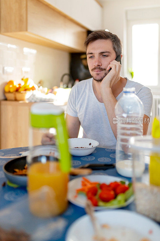 年轻人一边吃早餐，一边玩手机