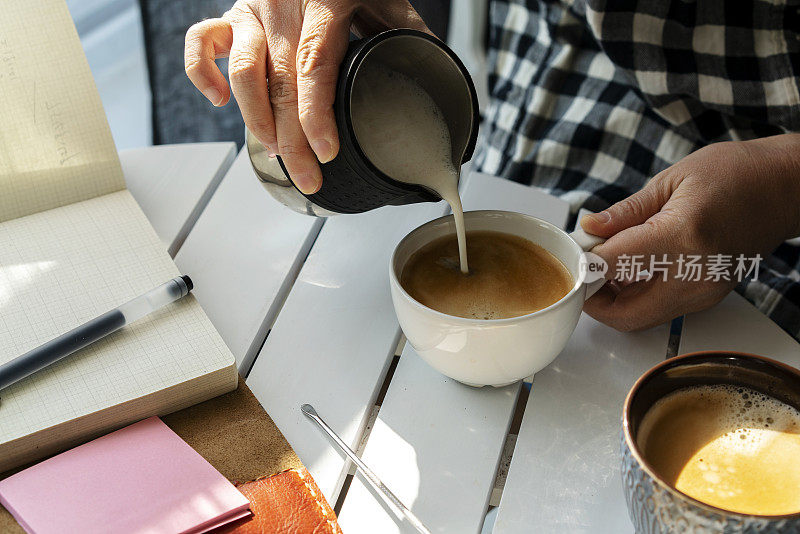 咖啡休息时间:把牛奶倒进浓咖啡里，制成一杯拿铁咖啡