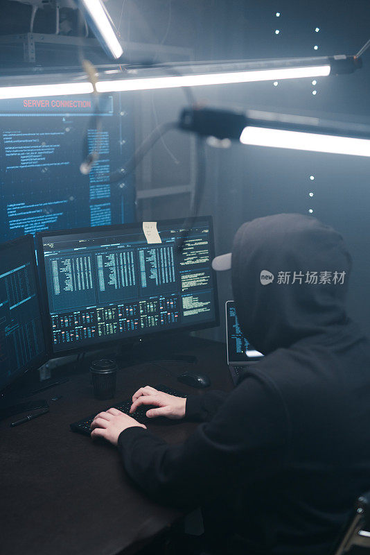 一个电脑黑客在笔记本电脑上的显示器背景上编写代码的俯视图。