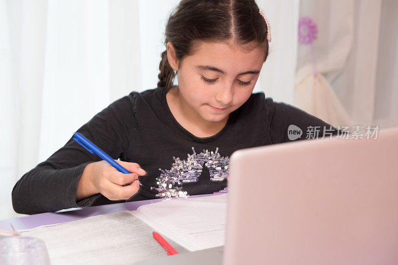 家庭教育和远程教育。小学。网上数学课上，小女孩在笔记本上写字