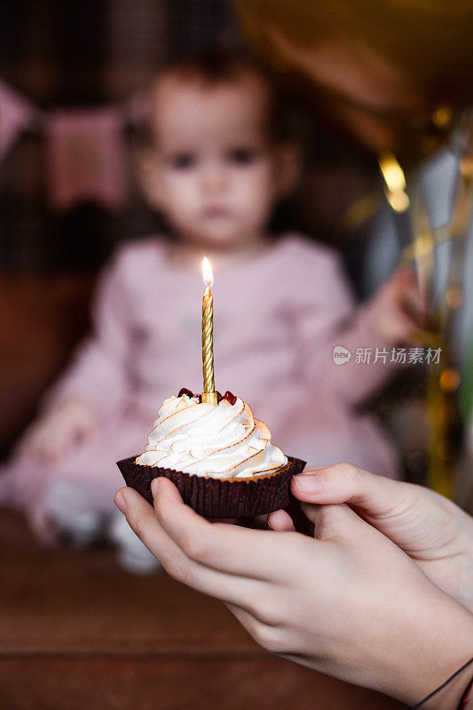 第一个生日蛋糕和一支蜡烛。在家给女儿过生日。