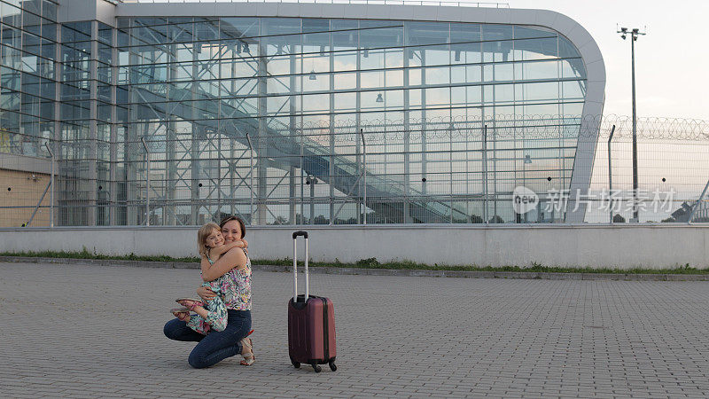 母亲迎接她的女儿孩子在机场航站楼张开双臂后，长时间的飞行假期工作