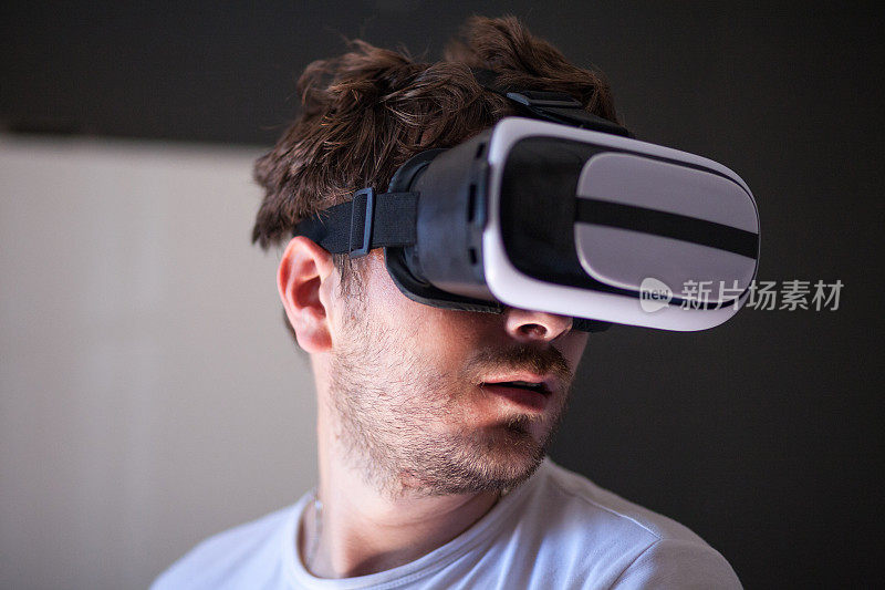 年轻人在家里使用虚拟现实模拟器耳机
