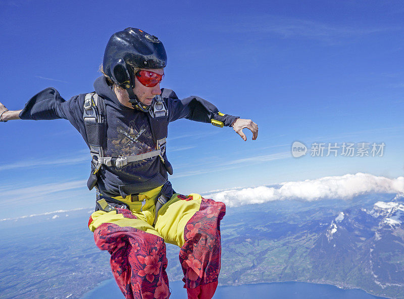 自由落体飞行者通过高山景观之上的崇高天空下降