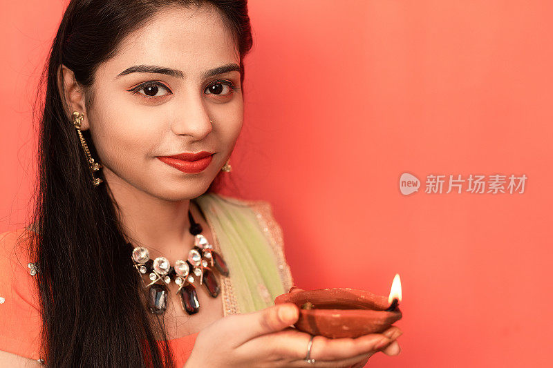 年轻的印度妇女拿着排灯节油灯